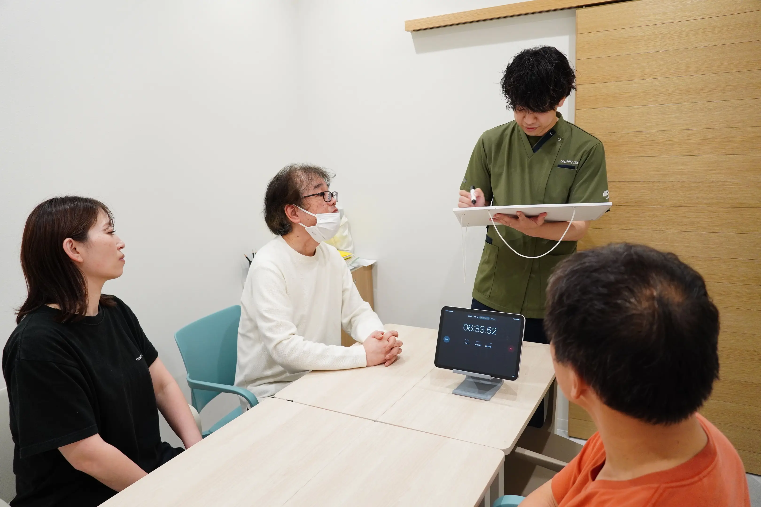 テーブルを囲み、ボードに書かれた内容を確認する人たち