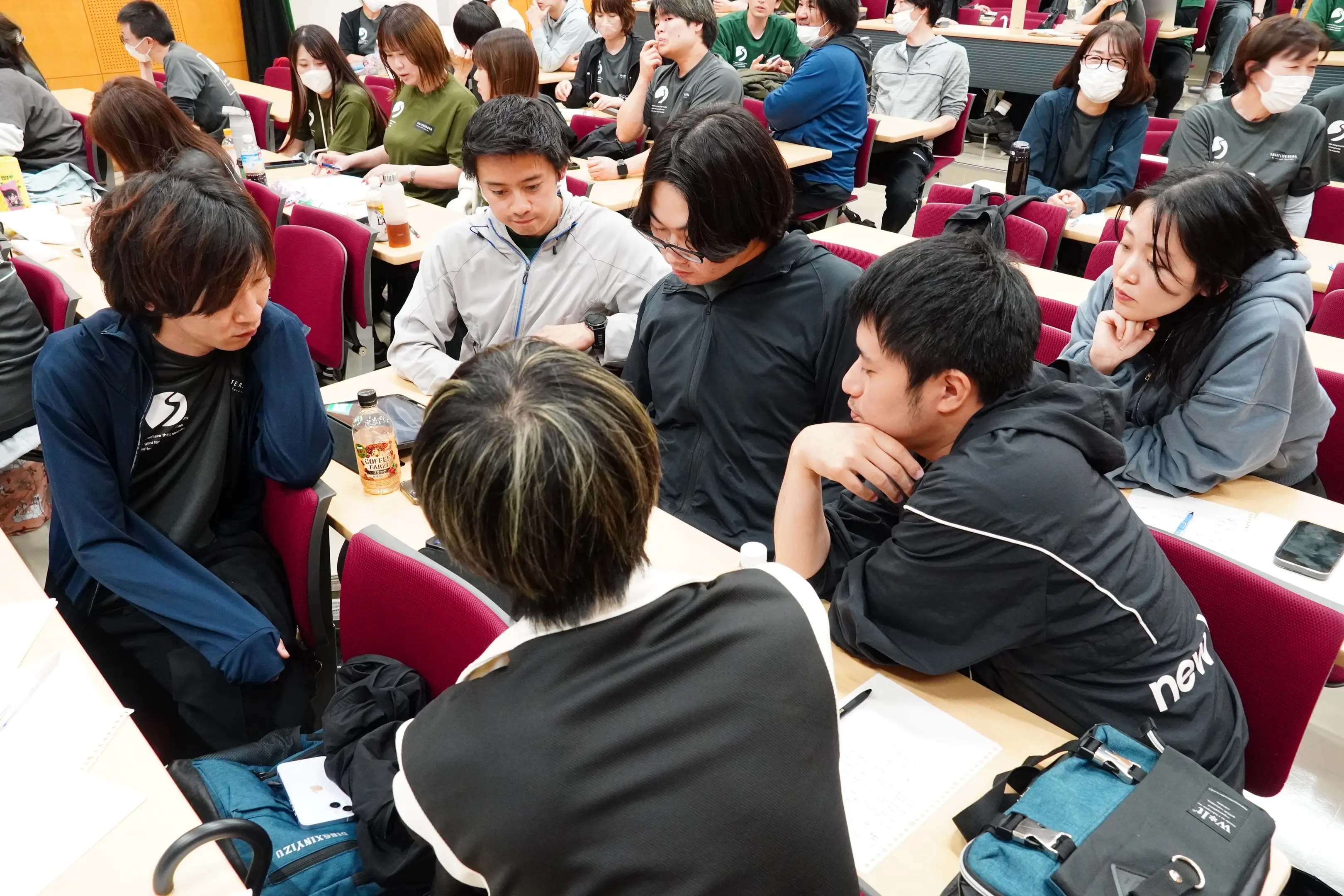 事業・職種を越えて話し合うスタッフ